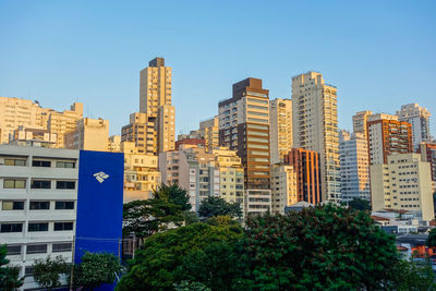 Buildings in city against clear sky