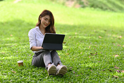Full length of woman sitting on field