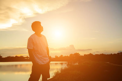 Full length of silhouette man standing against sky during sunset