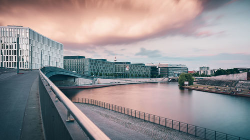 Bridge over river against cloudy sky