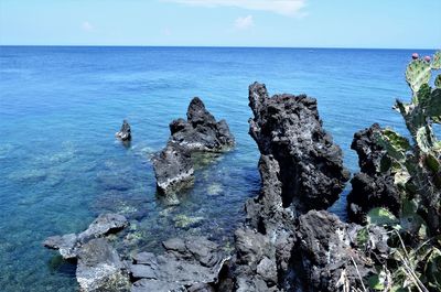 Panoramic shot of rocks in sea against sky
