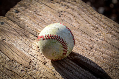 Used baseball on wooden bench in dugout