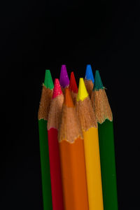 Close-up of colored pencils against black background