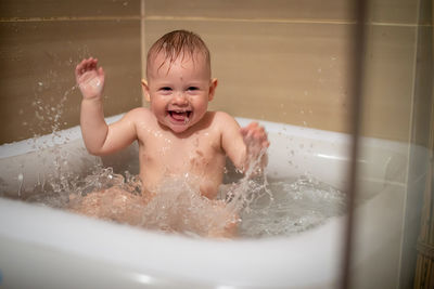 Portrait of smiling boy in bathtub