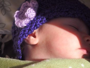 Sunlight falling on baby wearing knit hat sleeping at home