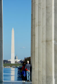 People in front of historical building against sky