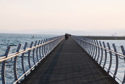 Pier over sea against sky during sunset