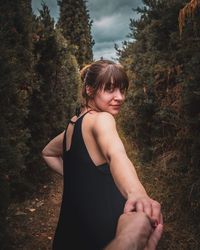 Midsection of woman standing by tree
