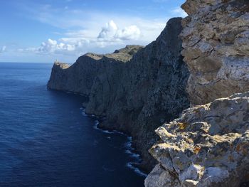 Rock formations by sea against sky