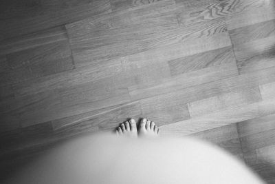 Low section of woman on hardwood floor