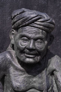 Close-up of old statue against wall