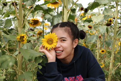 Portrait of smiling woman with yellow flower