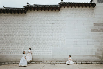 COUPLE SITTING ON BRICK WALL