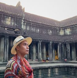 Mid adult man standing by historic temple against clear sky