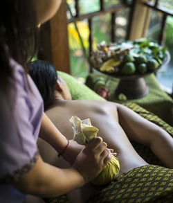 Midsection of woman getting herbal message at spa