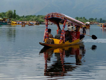 Traditional boat moored in water against sky