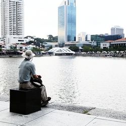 Rear view of woman sitting in river