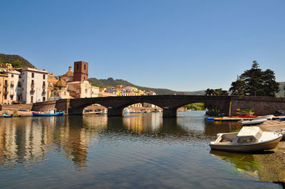 Bridge over river in city against clear sky