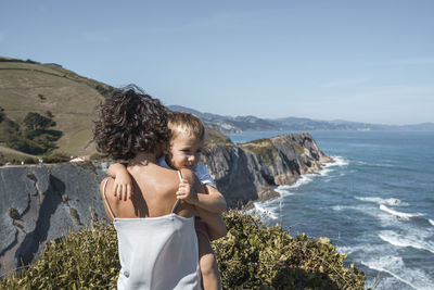 Mother with son at observation point against blue sky