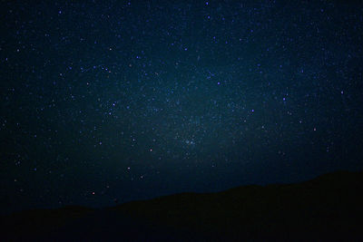 Low angle view of silhouette mountain against sky at night