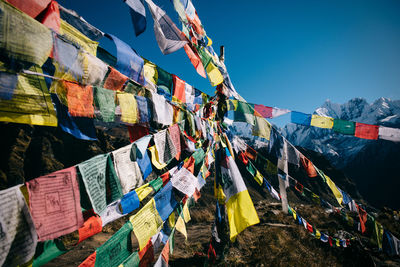 Low angle view of colorful flags hanging against sky