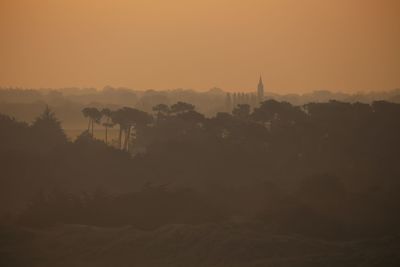 Silhouette of buildings in city during sunset