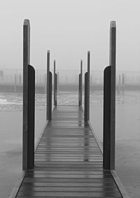 Wooden pier on sea against clear sky