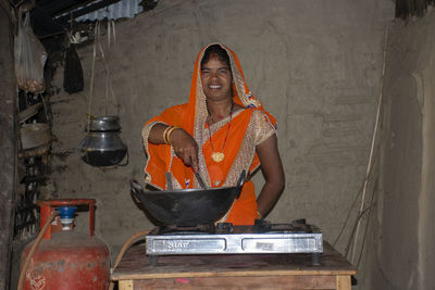 Portrait of smiling woman preparing food in kitchen