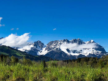 Scenic view of snowcapped mountains against blue sky