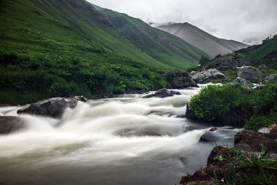 Scenic view of waterfall against sky