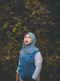 Portrait of beautiful young woman standing in autumn