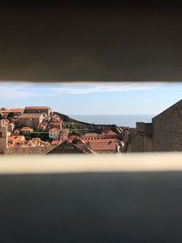 Houses in town by sea against sky