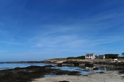 Buildings at waterfront against blue sky