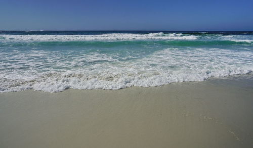 Blue sky, white waves and sunshine sandy beach at pacific coast, california