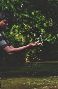 Side view of man in lake against trees