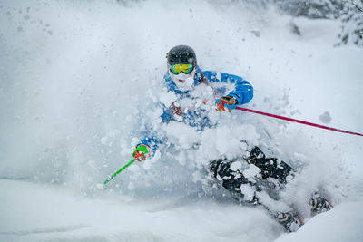 Person skiing on snowcapped mountain during winter