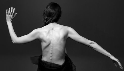 Close-up of young woman against black background
