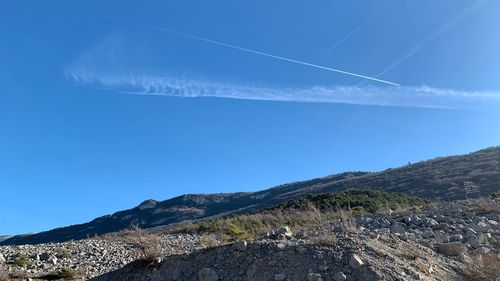 Low angle view of mountain against blue sky