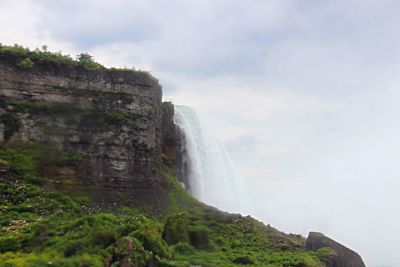 Scenic view of waterfall against sky