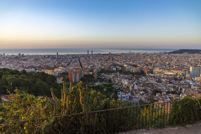 High angle view of townscape by sea against sky during sunset