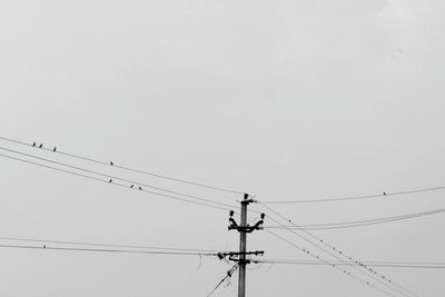 Low angle view of power lines against clear sky