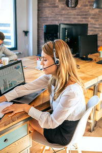 Young woman with headset in customer service of coworking