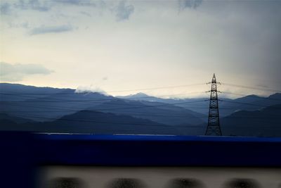 Electricity pylon on mountain against sky