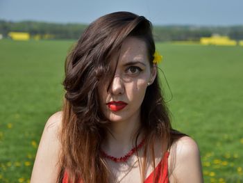 Portrait of beautiful young woman on field