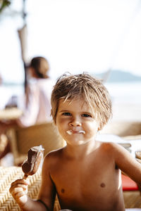 Portrait of smiling boy having ice cream in resort on sunny day