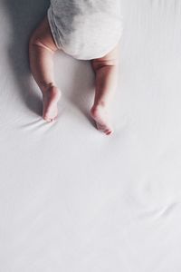 Low section of woman lying on bed