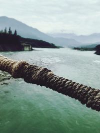 Close-up of rope on lake against sky