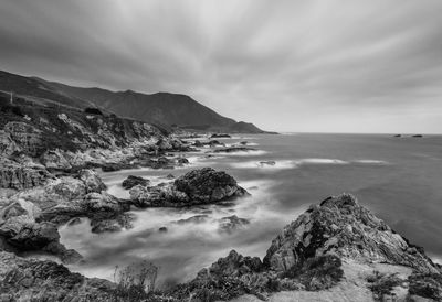 Scenic view of sea and mountains against sky