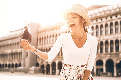 Young woman wearing hat in city