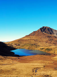 Pond by mountain against sky